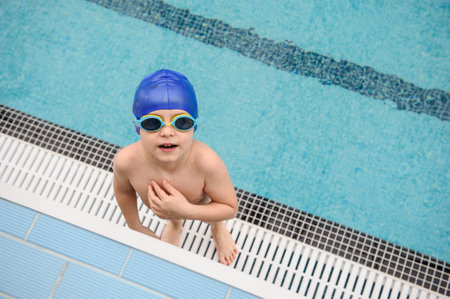 close up photo of a 7-year boy playing and swimming in the swimming poolの写真素材