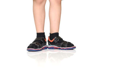close up photo boy's legs in black sandals with socksの写真素材