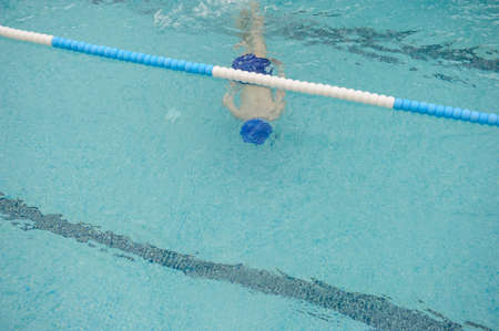 top view of a 7-year boy playing and swimming in the swimming poolの写真素材