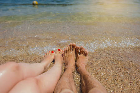top view of man and woman legs on the beachの写真素材