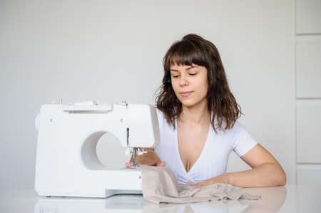 close up photo of a sexy brunette working at the sewing machineの写真素材