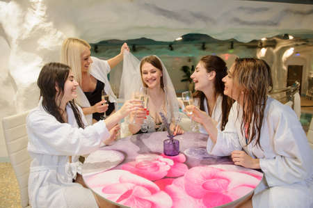 close up photo of smiling females drinking champagne at a bachelorette party in spa salonの写真素材