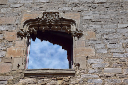Architectural window with a bas-relief in which the clouds are reflected
