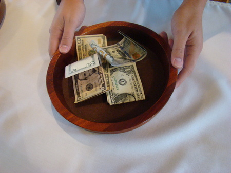 Hands holding Religious Offering Collection Plateの写真素材