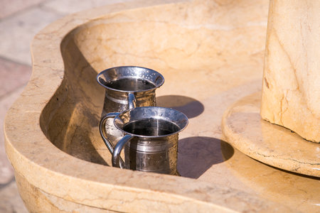 Silver washing mugs, for the purification or ablution ritual consisting of handwashing prior to prayer. Washing stations in the Plaza del Muro.の写真素材