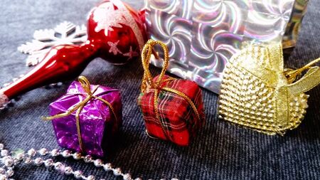 New Year's multicolored, shiny gifts, boxes, balls, decorations, bags. Festive accessories for the New Year. Items are on a dark backgroundの写真素材