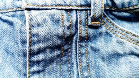 Rough, tough, dense twill weave, from which classic jeans are sewn. Traditionally, denim in indigo dyed only the warp thread. The seams are stitched with thick cotton threads of dark yellow color.の写真素材