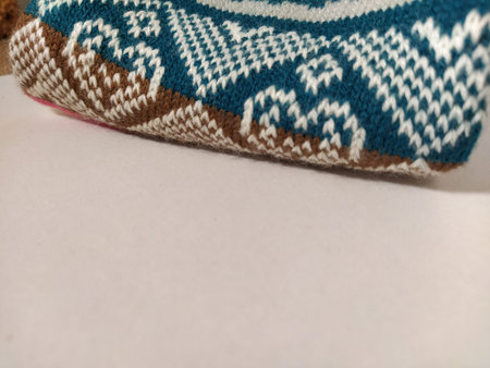 A fragment of an ornament on a knitted polyester or woolen sweater. Winter motives. Rhombuses,...