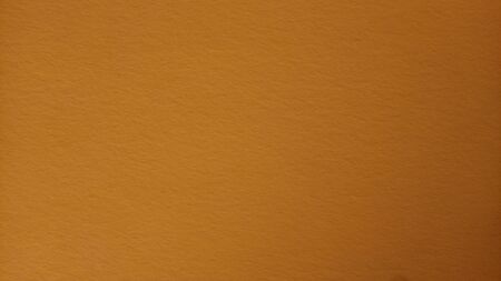Ocher color background. Colored paper dimly lit in the middle. Light dark vignetting around the edges. The play of light and shadow. Can be used as background. Light vignetting, darker on the right.の写真素材