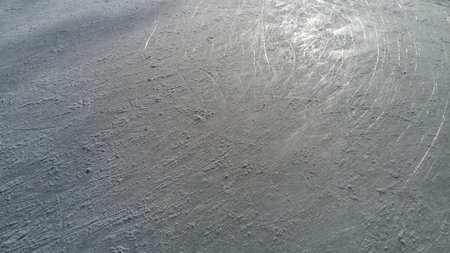 Ice streaked with the tip of figure skates. Figure skating on ice. The surface of the ice rink after...
