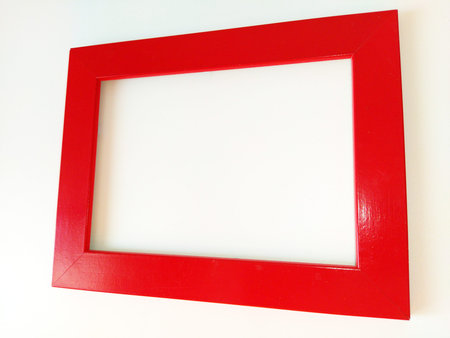 Red photo frame on a white background. The frame is photographed at an angle. Shiny lacquered wood...
