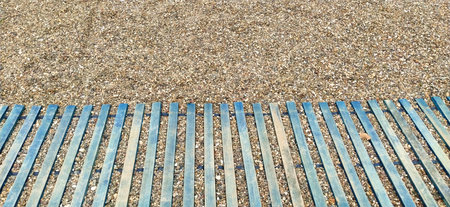 wooden boardwalk on the sand. wooden walkway on the beach. Sticks and boards on rocky ground. Heel...