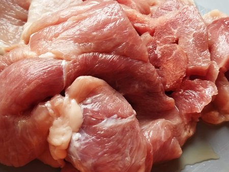 A juicy large piece of pork meat on a gray surface. Meat thawed or steamed, from which blood juice...