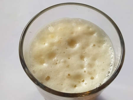 Beer from the top. Close-up of thick beer foam in a glass. Large and small bubbles.の写真素材