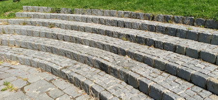 Semicircular steps of the amphitheater. Wide staircase made of stone blocks or bricks. Uneven...