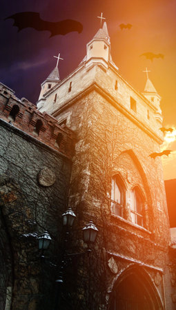 Horrible Halloween. Dawn after the night of the witches. Divine glow over the vampire hideout. Flying silhouettes of bats. Dramatic sky. Old stone walls. Street lightのeditorial素材