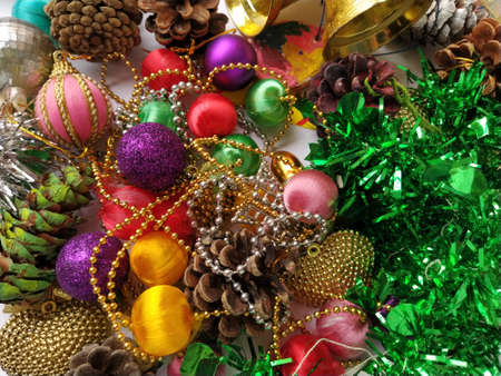 Christmas decoration collection. Beautifully arranged shiny bright Christmas tree decorations, green foil, gifts. Red, purple, yellow colorful decor elements for New Year and Christmas.の写真素材