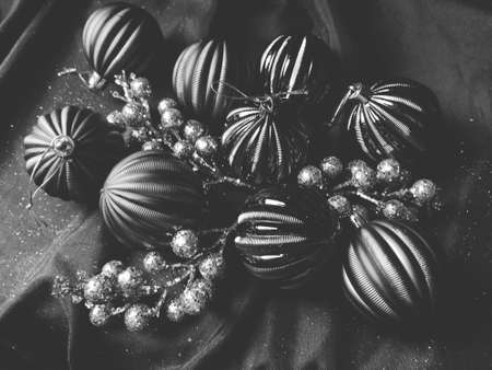 card for the new year and christmas with decorations, Christmas decorations and sparkles on a black background. Shiny striped balls, flowers and twigs with berries. Black and white, monochromeの写真素材