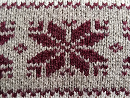 Knitted patterns with snowflakes, flowers, broken stripes. Burgundy, red and white woolen threads....