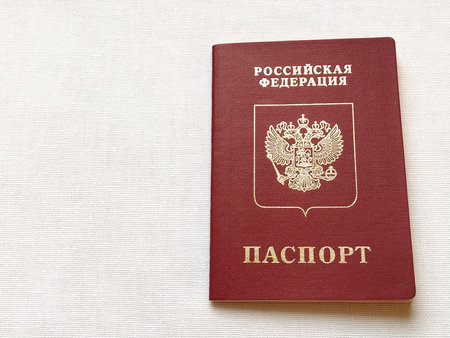 Passport of a citizen of the Russian Federation. International passport for travel and border crossing. Burgundy document cover with embossed gold letters. White background from textile.のeditorial素材
