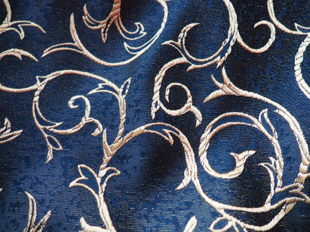 silk blue fabric with golden curls. Textiles for upholstery, curtains and festive clothing. The fabric is softly folded in wavesの写真素材