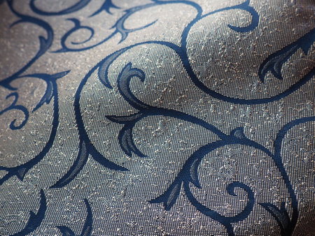silk blue fabric with golden curls. Textiles for upholstery, curtains and festive clothing. The fabric is softly folded in wavesの写真素材