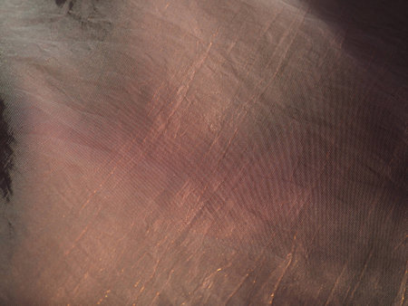 Beautiful fabric - taffeta, gently folded in waves. Crumpled material that looks like silk or brocade. Overflow and color gradient at different lighting angles. Fabric for sewing clothes and curtains.の写真素材