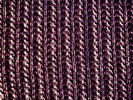 knitted pattern of pink or red yarn. Lush machine or hand knitting. Warm wardrobe for the...