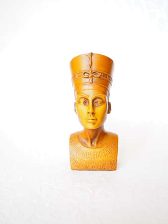 Bust or statue of the ancient Egyptian queen Nefertiti made of brown stone on a white background. The symbol of eternal female beauty. Isolate. Front view of the face.の写真素材