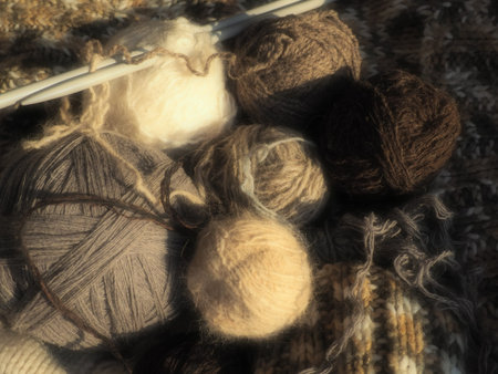 Balls of yarn, knitted clothes, knitting needles and crochet hooks. Knitting as a hobby. Brown,...