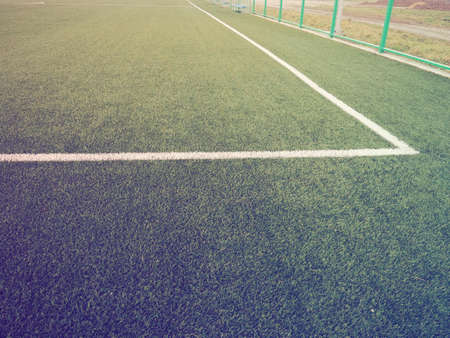 The marking of the football field on the green grass. White lines no more than 12 cm or 5 inches wide. Football field area. Side lines, goal lines. Sun glare. Color and light gradient.の写真素材