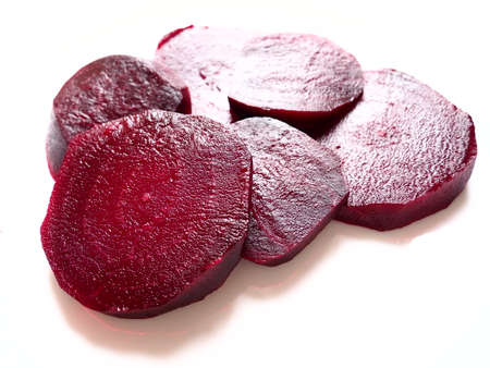 beets on a plate on a white plate. Beetroot mugs with inner texture, veins and a damp surface. Vegetarian or vegetable wellness menu. Vegetable health food. Bright burgundy or red colorの写真素材