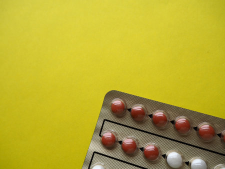 Heap of pills on yellow background. Tablets, vitamins and blisters with capsules for the treatment...