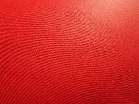 Abstract red background with texture. Close-up of paper surface with light and color gradient. Side lighting. Bright crimson backdrop.の写真素材
