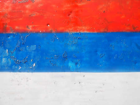 Serbian flag, tricolor red, blue, white painted on a metal surface. Peeling paint.の写真素材