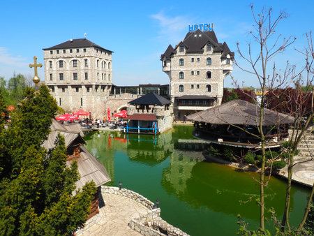 Stanisici, Bijelina, Republika Srpska, Bosnia and Herzegovina April 25 2021 Ethno village, tourism and attractions. Stone and wooden buildings of the hotel. People visit restaurant, traditional housesのeditorial素材