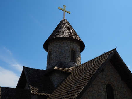 Stanisici, Bijelina, Bosnia and Herzegovina, April 25, 2021. Stone Orthodox church in the ethno-park. Religious tourism. A building made of stones with a cross on the dome. Blue sky.のeditorial素材