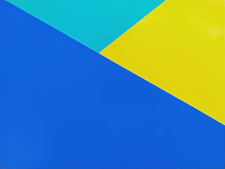 Blue, green, and yellow colored paper stacked on top of each other. Colorful background.の写真素材