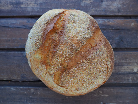 top view of round bread. Delicious fresh cornbread with sprinkles on an old wooden table. Copy...