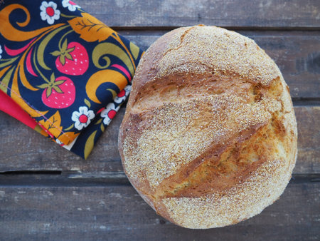 round bread top view. Delicious fresh cornbread with sprinkles on an old wooden table and a...