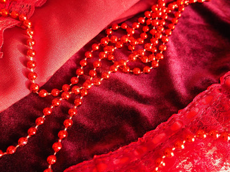 Red beautiful beads on bright scarlet velvet. Beautiful luxurious women's jewelry on soft fabric....
