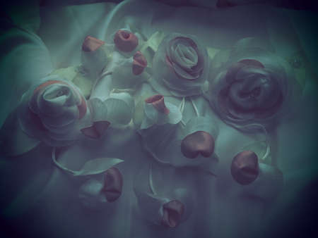Wedding flowers made of fabric for the decoration of the bride's wedding dress. Vintage style, blurry foggy image. Several artificial flowers and buds made of silk. Wedding decorations for ceremony.の写真素材