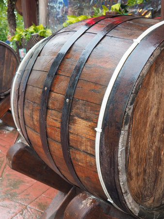 A traditional old wooden barrel with curved walls and metal hoops. Dishes for the ripening of...