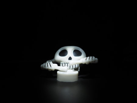 Skull with drumsticks and drum. Terrible clockwork toy. The skeleton is made of the skull, bones,...