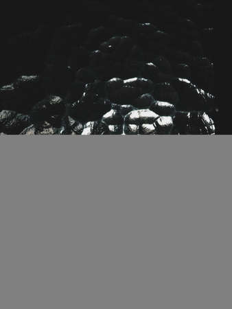 Corrugated glass, rear light source. The play of glare and reflections in a transparent uneven surface. Dark and light abstract asymmetrical multi-illuminated planes. Abstract weird backgroundの写真素材