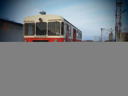 Retro train wagon of red color. Vintage locomotive made in Yugoslavia. Sremska Mitrovica, Serbia. The metal body of a railway vehicle. Rusty railroad station. Empty carriage at a dead end. Vignetteの写真素材