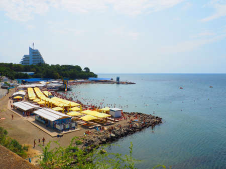 Anapa, Russia, August 23, 2021 Vysokiy Bereg beach or Kamenka. Stone pebbles on the beach. Tourists swim and sunbathe. Summer day. Clear water in Black Sea. Leisure and tourism. Artificial embankmentのeditorial素材