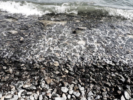 Sea rocky beach with waves, Sukko, Anapa, Krasnodar Territory, Russia. Sea foam on a pebble beach...