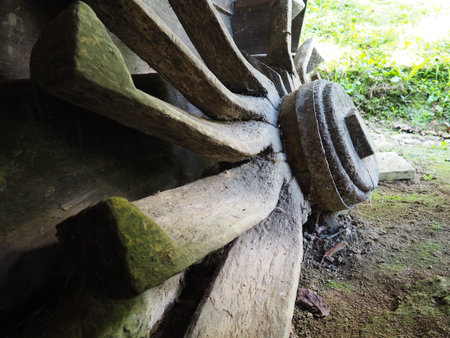 Old cart wheel on the farm. Wooden wagon wheel. Large blades from a cart wheel close-up. Wood...