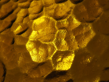 golden yellow corrugated glass with a light and dark background. reflections of light. Corrugated...